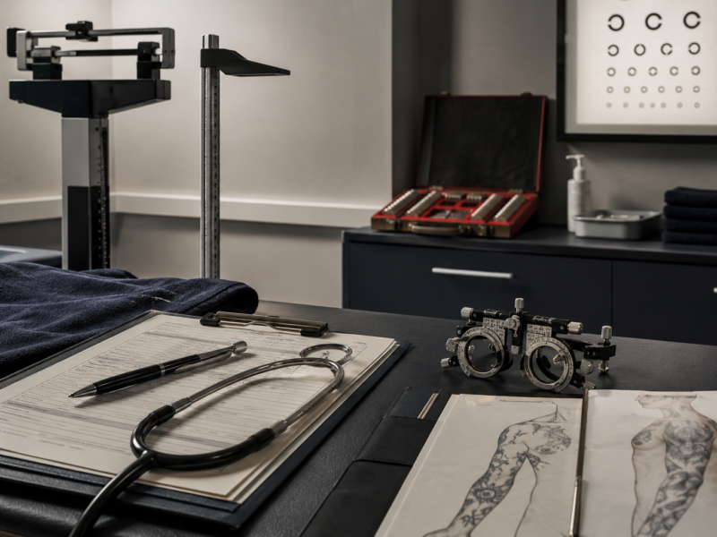 Ambulatorio medico con strumenti diagnostici, schede di valutazione, tavola optometrica e documenti per l’idoneità nei concorsi militari